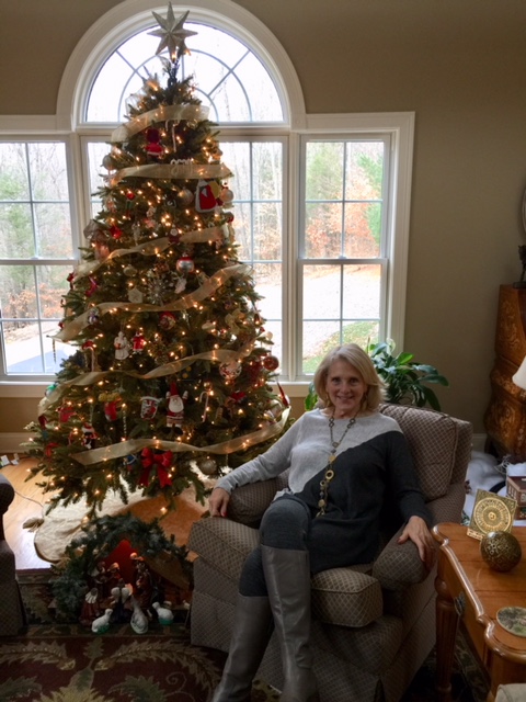 Pam sitting by Christmas tree